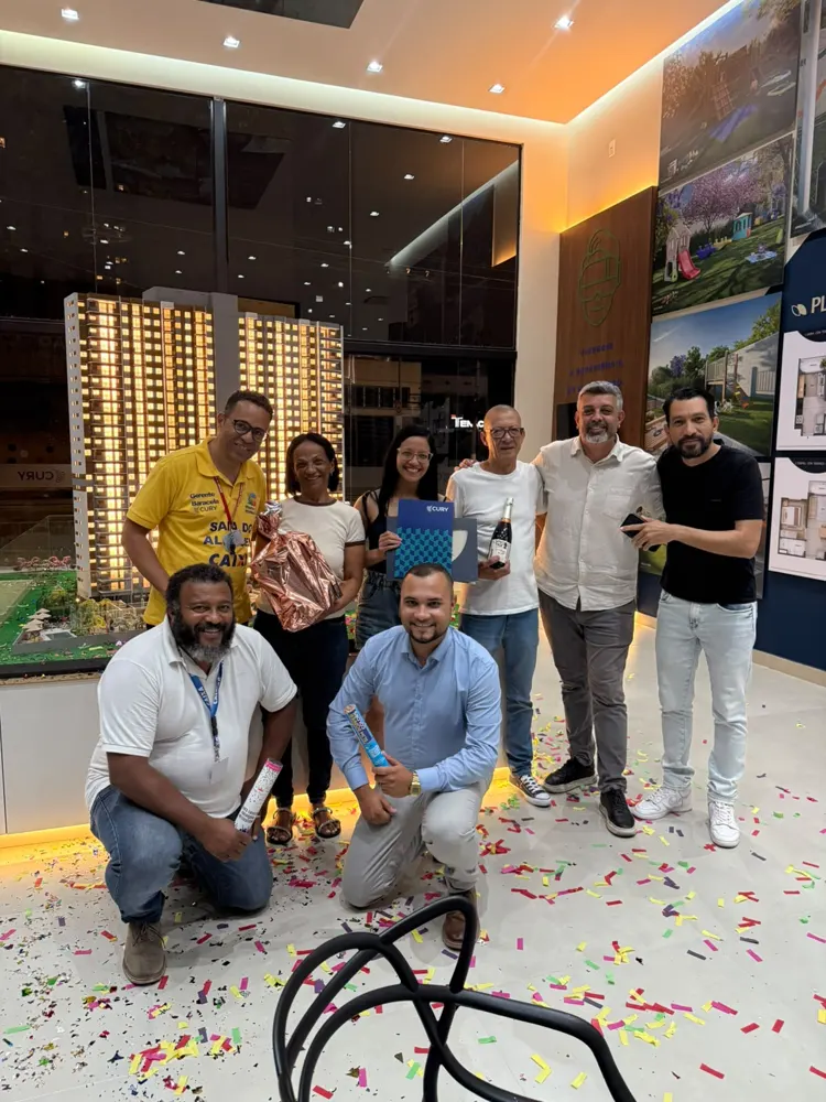 Corretores e clientes comemorando uma venda no stand da Cury